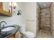 Modern bathroom features a wood accent wall in the shower, a vanity with black countertop, and a pebble floor at 8795 Rudd Rd, Evergreen, CO 80439