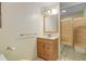Small, carpeted bathroom featuring a wood cabinet sink and wood saloon doors that open into another room at 8795 Rudd Rd, Evergreen, CO 80439