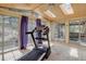 Bright exercise room with hardwood floors, a ceiling fan and multiple skylights to fill the room with natural light at 8795 Rudd Rd, Evergreen, CO 80439