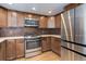 Well-appointed kitchen with stainless steel appliances, wood cabinets, and modern finishes at 8795 Rudd Rd, Evergreen, CO 80439