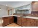 Beautiful kitchen featuring wood cabinets, modern countertops and appliances and a view to gazebo at 8795 Rudd Rd, Evergreen, CO 80439