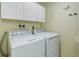 Bright laundry room with white washer and dryer units, white cabinets, and neutral-toned walls at 8795 Rudd Rd, Evergreen, CO 80439