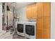 Functional laundry room with modern machines and wooden cabinets at 3692 Celestial Ave, Castle Rock, CO 80109