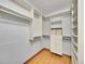 Spacious walk-in closet featuring custom shelving, drawers, and ample storage space with hardwood floors at 1605 Saint Paul St # 6, Denver, CO 80206