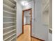 Hallway with neutral paint, hardwood floors, open to another room, and built in shelving at 1605 Saint Paul St # 6, Denver, CO 80206