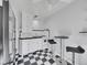 Efficient kitchen featuring a breakfast bar, gas range, and stylish black and white tile flooring at 1605 Saint Paul St # 6, Denver, CO 80206