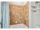 Clean bathroom featuring a white bathtub and a neutral tile shower with a showerhead, along with wall shelves at 6019 S Little River Way, Aurora, CO 80016