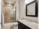 Bathroom featuring granite countertop, modern sink, shower, mosaic tile accents, and sliding glass door at 6019 S Little River Way, Aurora, CO 80016