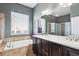 Elegant bathroom featuring a soaking tub, double vanity, and a separate glass-enclosed shower at 6019 S Little River Way, Aurora, CO 80016