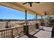 Covered deck featuring wooden railings, ceiling fans and serene views of open landscape and neighborhood at 6019 S Little River Way, Aurora, CO 80016