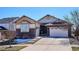 Charming home with a stone facade, three-car garage, and a well-manicured lawn at 6019 S Little River Way, Aurora, CO 80016