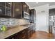 Modern kitchen with stainless steel appliances, dark cabinetry, and a stylish backsplash for a sleek look at 6019 S Little River Way, Aurora, CO 80016