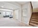 Open-concept living room with stairway, grey sofa, carpeted floors, and a neutral paint color at 6019 S Little River Way, Aurora, CO 80016