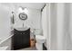 Bathroom with dark vanity, toilet, mirror, and shower behind curtain at 2200 Teller St, Lakewood, CO 80214