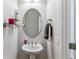 Modern powder room with a pedestal sink, oval mirror, and decorative accents at 25402 E Glasgow Pl, Aurora, CO 80016