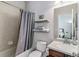Clean bathroom featuring a shower/tub with curtain, floating shelves, and a vanity at 25402 E Glasgow Pl, Aurora, CO 80016