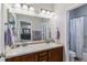 Well-lit bathroom with dual sinks, tile floors, and a shower with a curtain at 25402 E Glasgow Pl, Aurora, CO 80016