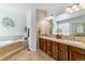 Bright bathroom with dual sinks, tile floors, soaking tub, and decorative accents at 25402 E Glasgow Pl, Aurora, CO 80016
