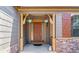 Inviting entryway with hanging flower baskets, decorative stone accents, and a charming covered porch at 25402 E Glasgow Pl, Aurora, CO 80016