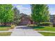 Charming two-story home with a well-manicured lawn, mature trees, and a spacious driveway leading to an attached two-car garage at 25402 E Glasgow Pl, Aurora, CO 80016