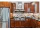 Well-equipped kitchen with stainless steel appliances, granite countertops, and rich wood cabinetry at 25402 E Glasgow Pl, Aurora, CO 80016