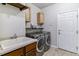 Functional laundry room with a utility sink, cabinets, and modern washer and dryer at 25402 E Glasgow Pl, Aurora, CO 80016