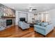 Inviting living room featuring a stone fireplace, hardwood floors, and comfortable seating at 25402 E Glasgow Pl, Aurora, CO 80016