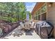 Cozy outdoor patio featuring stone retaining wall, comfortable seating, and a grill for entertaining at 25402 E Glasgow Pl, Aurora, CO 80016