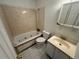 Bathroom featuring a jacuzzi tub, sink, and toilet against tiled walls at 7431 Webster St, Arvada, CO 80003