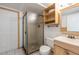 Bathroom with tiled floors, glass shower, sink, and shelving at 7431 Webster St, Arvada, CO 80003