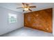 A bedroom features a unique wood accent wall and a bright window overlooking the outdoors at 7431 Webster St, Arvada, CO 80003