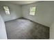 Bedroom with neutral carpeting, white walls, and two windows bringing in natural light at 7431 Webster St, Arvada, CO 80003
