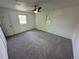 Bright bedroom with neutral carpeting, white walls, and two windows with a ceiling fan at 7431 Webster St, Arvada, CO 80003