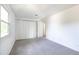 This bedroom has neutral carpeting, white walls, closet storage, and a bright window at 7431 Webster St, Arvada, CO 80003