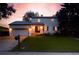 Charming two-story home with a well-maintained lawn and an attached garage, showcased at sunset at 7431 Webster St, Arvada, CO 80003