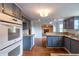 Functional kitchen with updated cabinets, opening to a cozy area with a fireplace at 7431 Webster St, Arvada, CO 80003