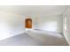 Spacious living room with soft carpeting and arched entryway to a cozy wood paneled room at 7431 Webster St, Arvada, CO 80003