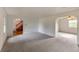 Spacious living room with soft carpeting and arched entryway to wooden staircase at 7431 Webster St, Arvada, CO 80003