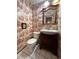 Charming powder room featuring a decorative wallpaper, wooden vanity, and tiled floors at 7431 Webster St, Arvada, CO 80003
