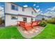 The backyard of this home features a wood deck with built-in bench, a grassy lawn, and a partial shade awning at 12287 W Aqueduct Dr, Littleton, CO 80127