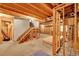 Unfinished basement area with exposed wooden framing and a stairway to upper level at 12287 W Aqueduct Dr, Littleton, CO 80127