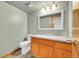 Bathroom featuring a modern vanity, toilet, mirror, and fixtures with neutral tones at 12287 W Aqueduct Dr, Littleton, CO 80127