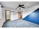 Spacious bedroom features blue accent wall, ceiling fan, closet, and easy access to other rooms at 12287 W Aqueduct Dr, Littleton, CO 80127