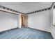 Simple bedroom with blue carpet and decorative border, showcasing closet entrance at 12287 W Aqueduct Dr, Littleton, CO 80127