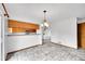 Open-concept dining area with views to the kitchen, bar, and an elegant chandelier at 12287 W Aqueduct Dr, Littleton, CO 80127