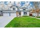 Charming two-story home with a lush green lawn, blue trim, and a three-car garage at 12287 W Aqueduct Dr, Littleton, CO 80127