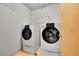 Functional laundry room with a washer and dryer set and storage shelves at 12287 W Aqueduct Dr, Littleton, CO 80127