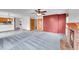 Open living room with a fireplace, a ceiling fan, and tile flooring adjoining a kitchen space at 12287 W Aqueduct Dr, Littleton, CO 80127