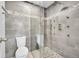 Updated shower with gray tile, pebble floor, and glass door, offering a spa-like experience at 12287 W Aqueduct Dr, Littleton, CO 80127