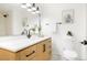 Modern bathroom features a wood vanity, neutral countertops, and a decorative mirror at 6190 W Canyon Ave, Littleton, CO 80128